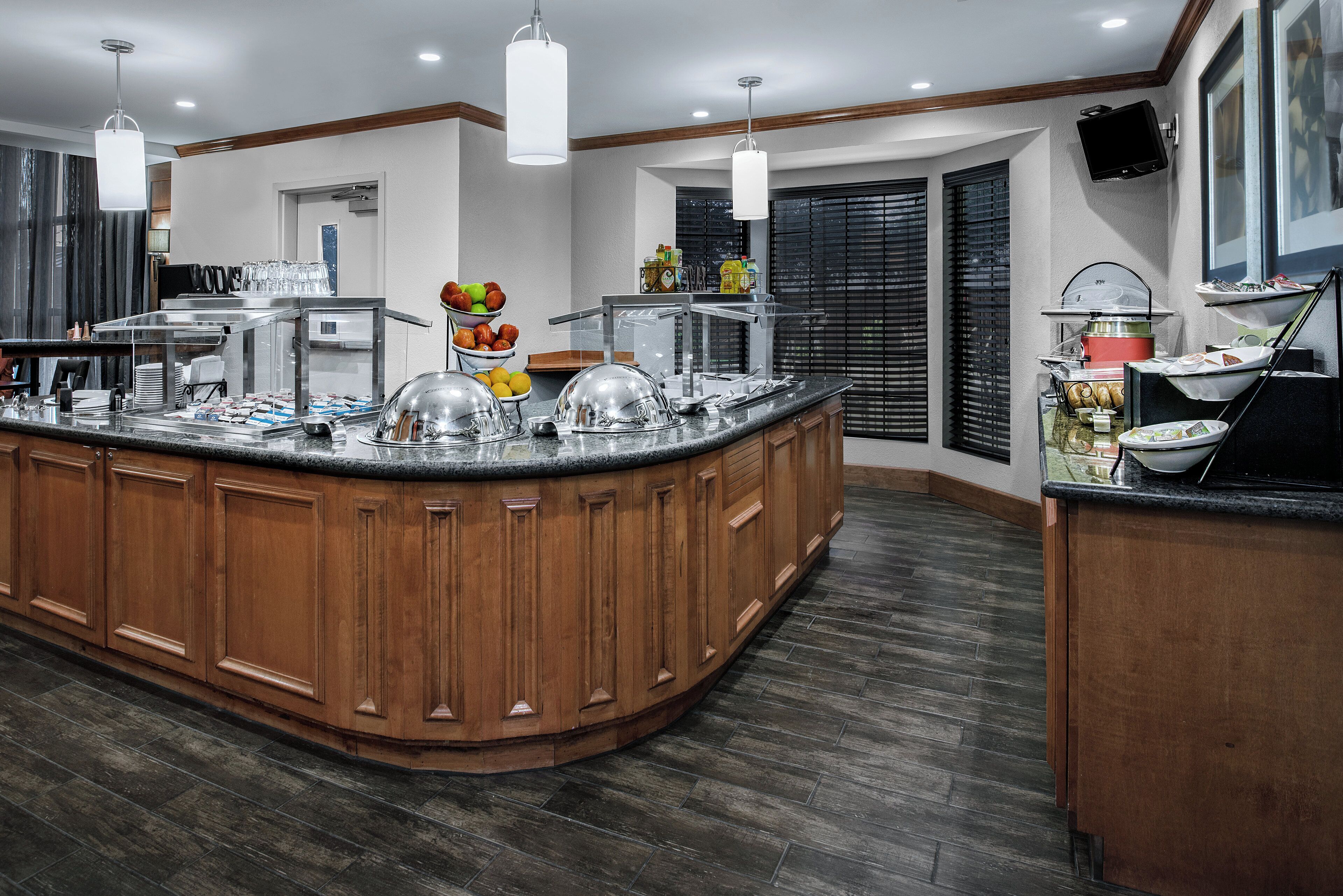 A kitchen with a large island, wooden cabinets, and a breakfast bar.