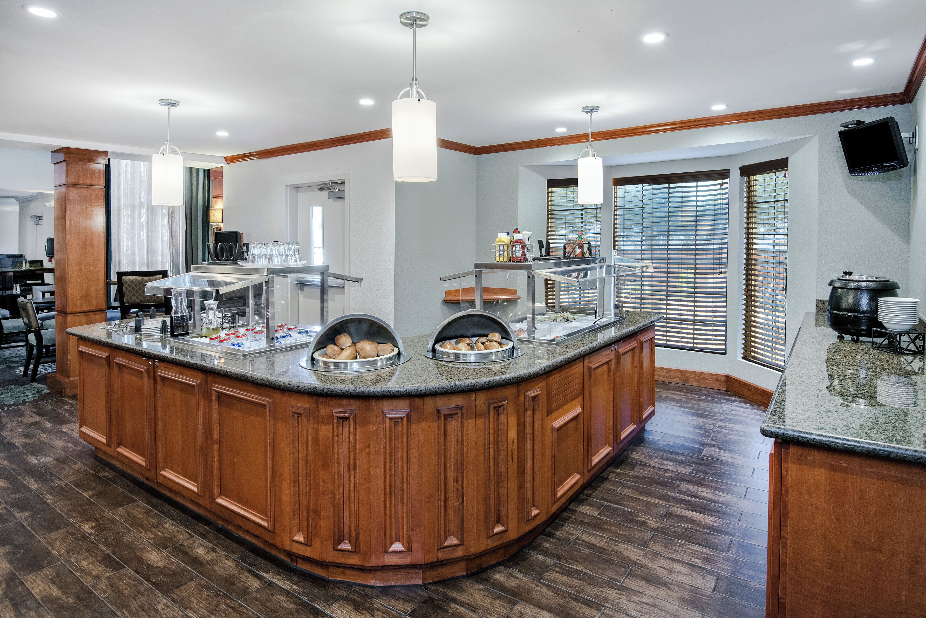 A large kitchen island with a wood finish, equipped with a sink and various food items.
