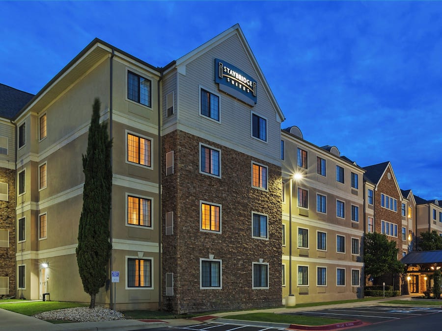 A multi-story hotel with a stone facade, multiple windows, and a sign indicating it is a Staybridge Suites hotel.