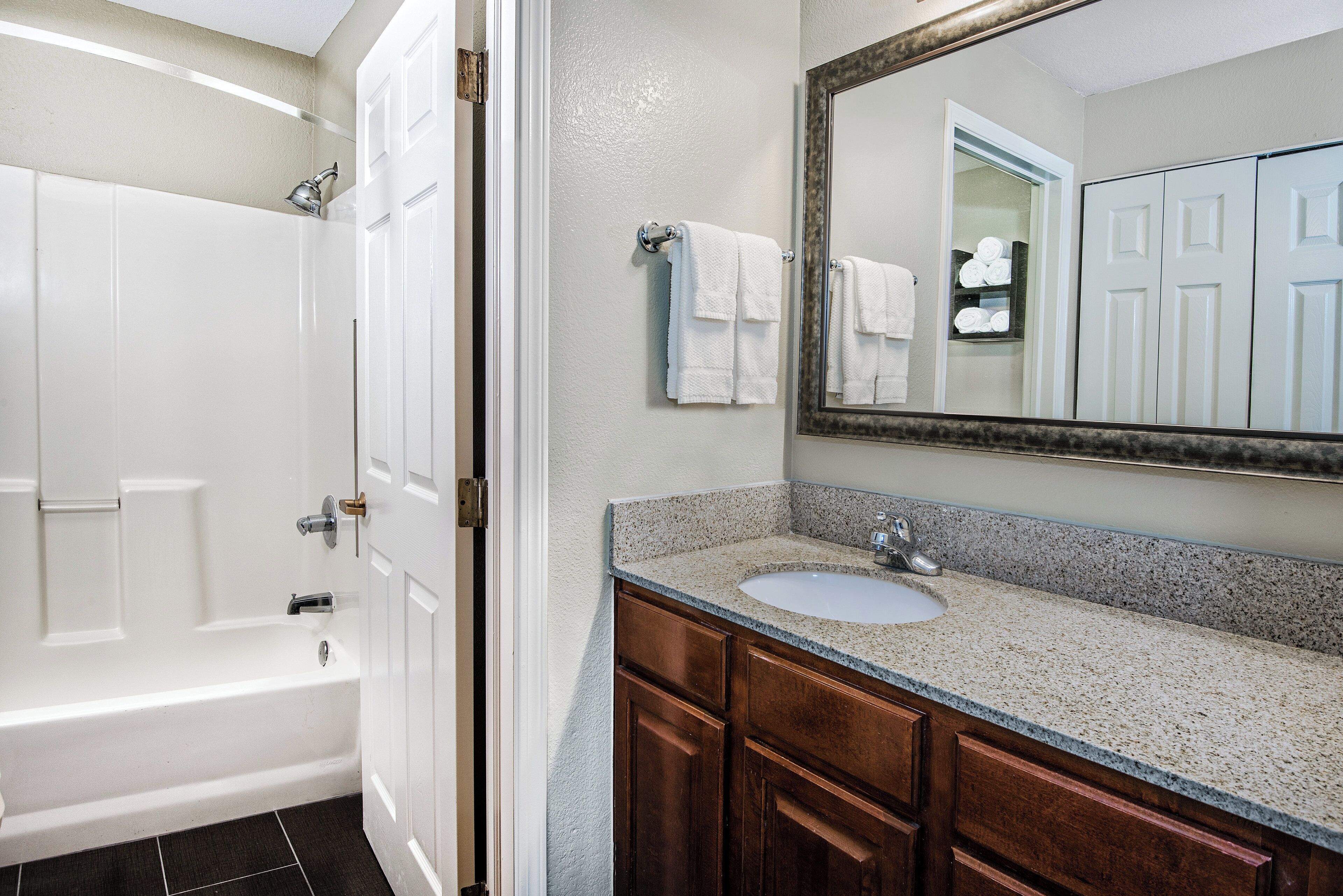 A bathroom with a bathtub, a sink, and a mirror.