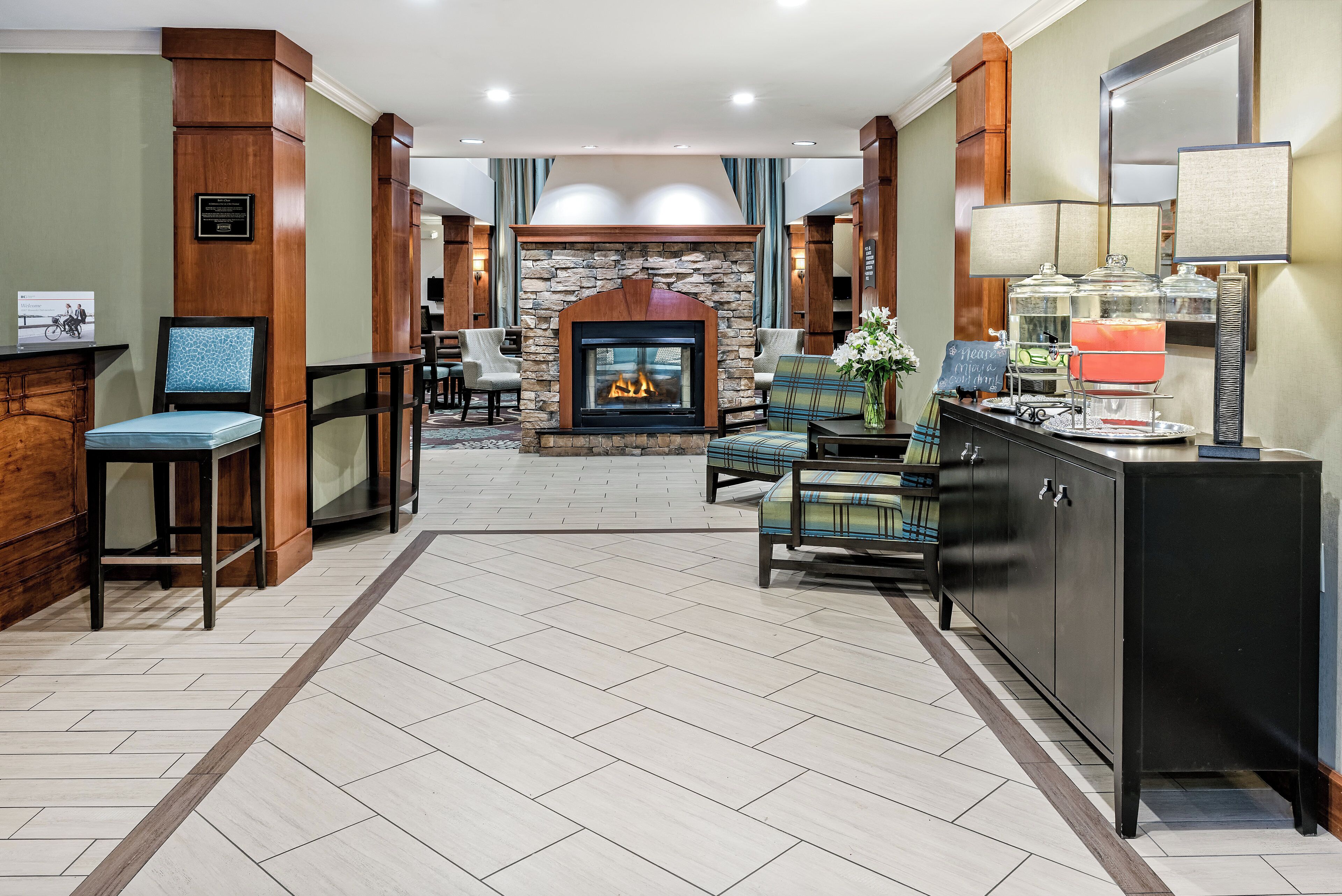 A hotel lobby with a fireplace, seating area, and a buffet counter.