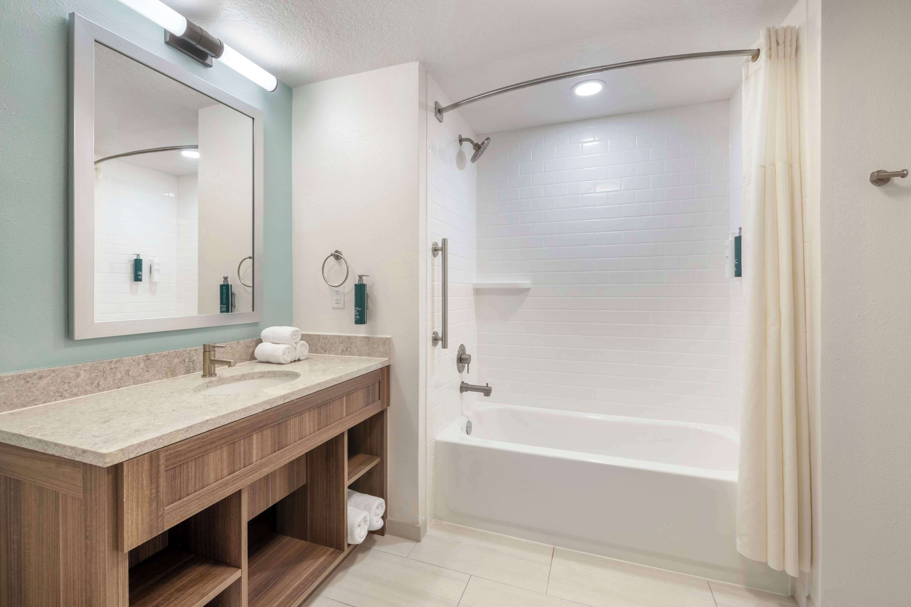 Un baño moderno con una bañera independiente, un tocador con espejo y una zona de ducha.
