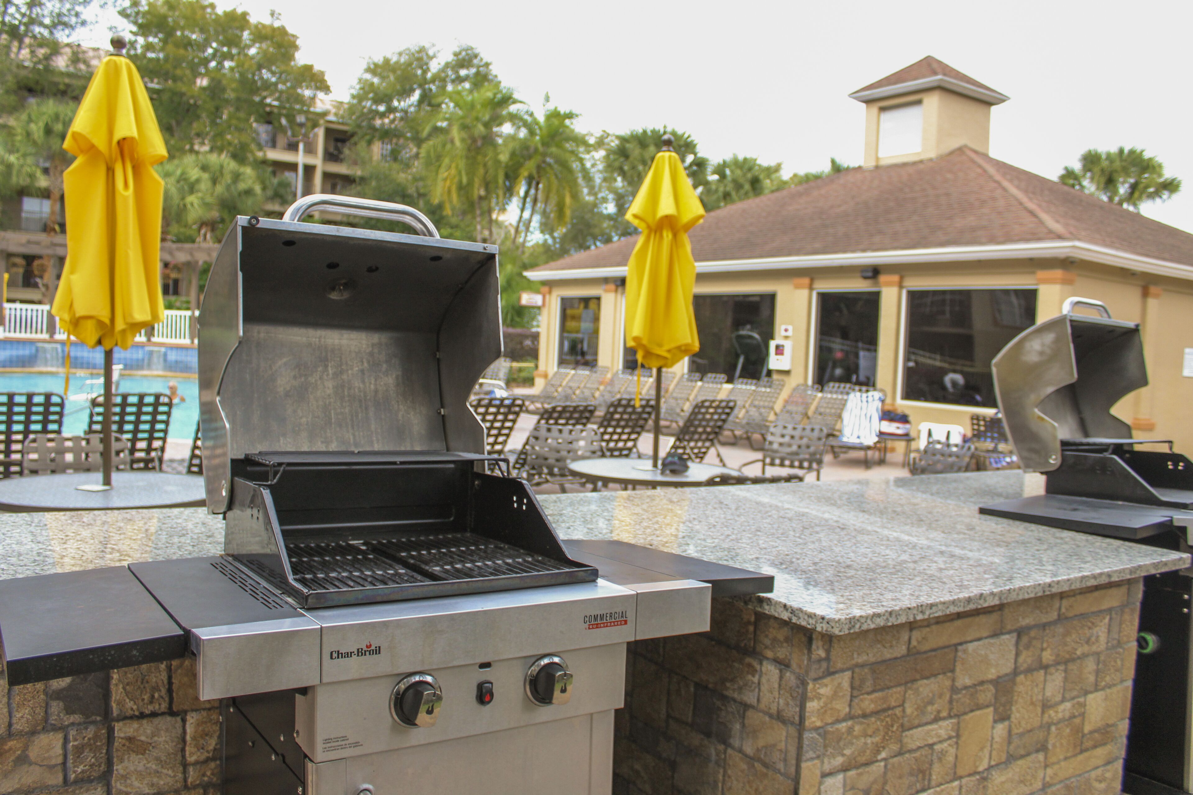 An outdoor grill area with a stone countertop and a commercial infrared grill.