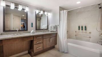 Un baño moderno con tocador doble, un espejo grande, bañera y zona de ducha.