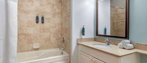 Un baño con bañera, lavamanos y espejo.