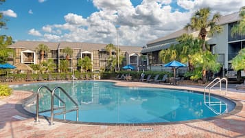 Una piscina al aire libre, tumbonas