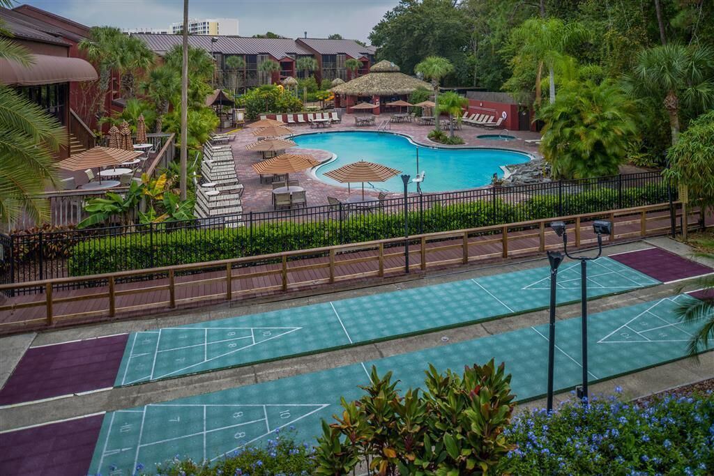 Ein Hotel mit Schwimmbad, Außenbereich zum Sitzen und einem Shuffleboard-Platz.