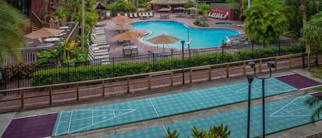 Ein Hotel mit Schwimmbad, Außenbereich zum Sitzen und einem Shuffleboard-Platz.