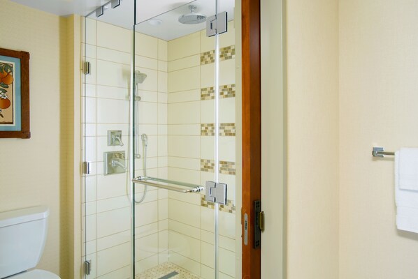A glass-enclosed shower with a tiled floor and a white toilet visible to the left. - Disney's Grand Californian Hotel and Spa (Anaheim)