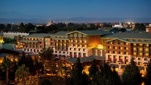 A multi-story hotel with a central courtyard, surrounded by trees and featuring multiple balconies.