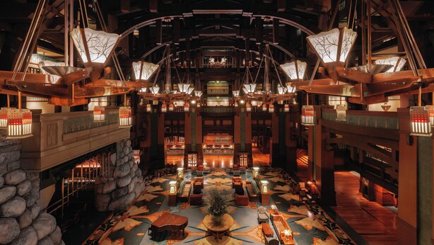 A spacious lobby with a central seating area, a stone wall, and a large chandelier.