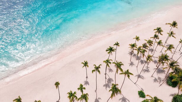Una playa con aguas turquesas cristalinas y una orilla arenosa.