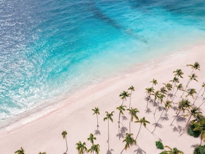 Una playa con aguas turquesas cristalinas y una orilla arenosa.