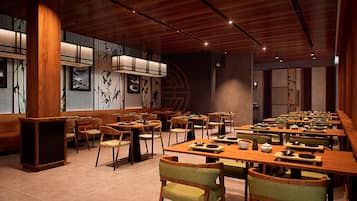 A restaurant with wooden tables and chairs, a tiled floor, and a traditional Asian decor.