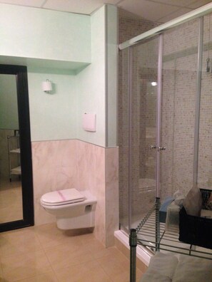 A bathroom with a toilet, a glass-enclosed shower, and a hand dryer. - Miceneo Palace Hotel (Scanzano Jonico)
