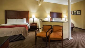 Ein Hotelzimmer mit einem Bett, zwei Nachttischen mit Lampen, einem Schreibtisch und einem Stuhl sowie einer großen Säule.