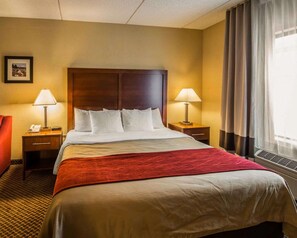 Relax in this inviting space with a large bed, two bedside tables, and a window with curtains.