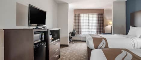 Habitación de hotel con televisión de pantalla plana, minibar, escritorio con silla, dos camas y un ventanal grande con cortinas.