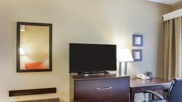 Hotelkamer met een flatscreen televisie, een bureau met een lamp, een stoel en een telefoon.