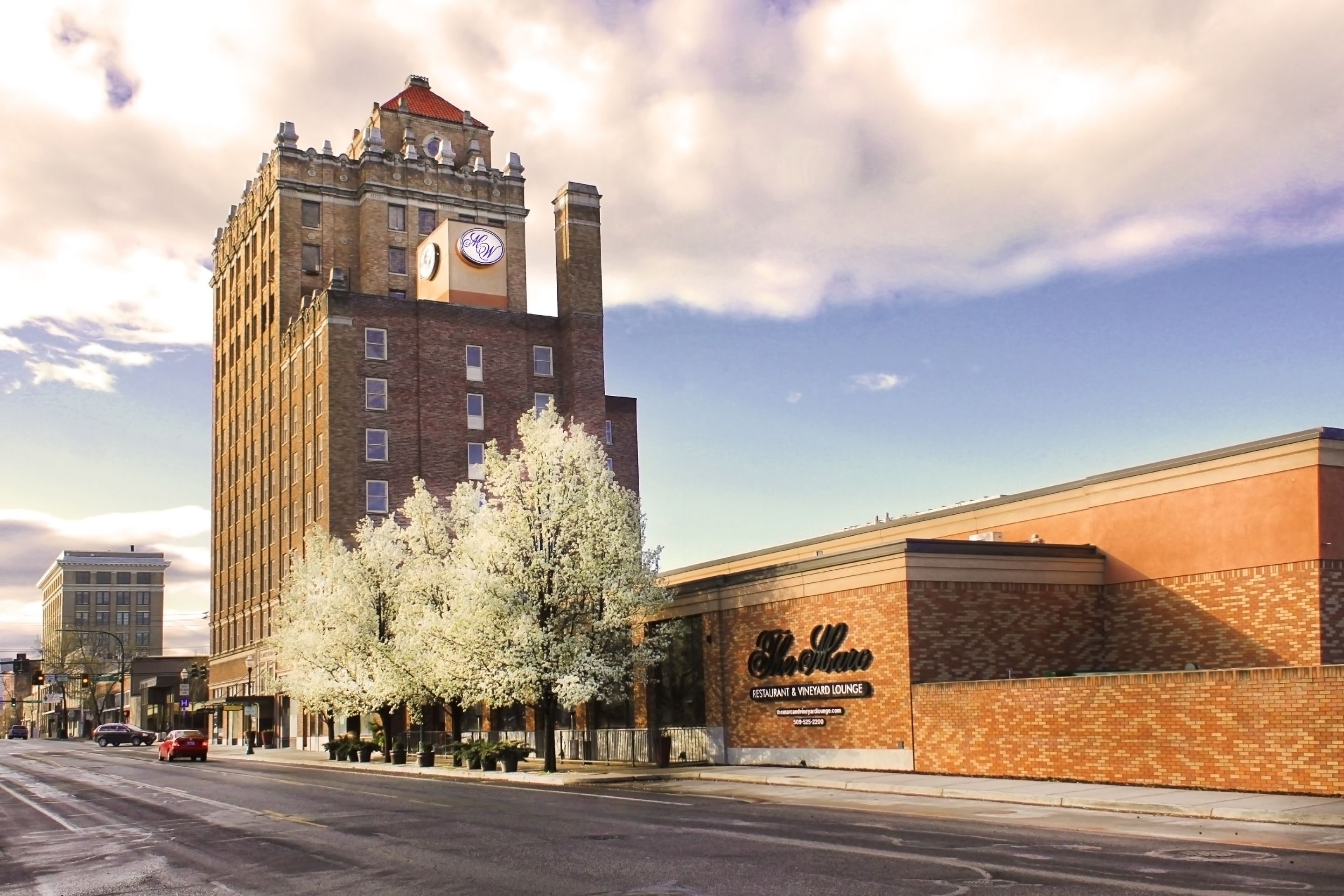 Un edificio alto de ladrillo con una torre del reloj y un letrero que dice 'The Illini Restaurant & Vineyard Lounge'.