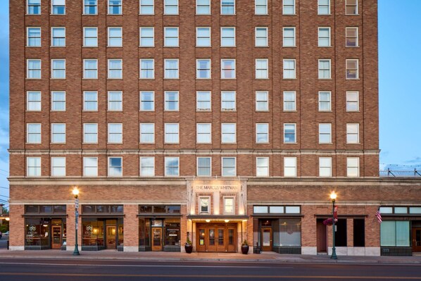 A multi-story brick building with a marquee sign reading "The Marcus Whitman."