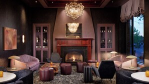 A modern lounge area with a fireplace, leather seating, and a chandelier. - The Marcus Whitman Hotel (Walla Walla)