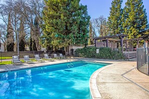 Una piscina al aire libre, tumbonas