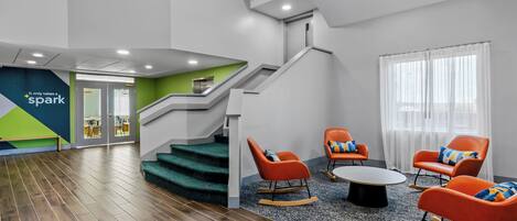 Ein modernes Interieur mit Treppe, Sitzgelegenheit und einer sichtbaren Tür zu einem anderen Raum.
