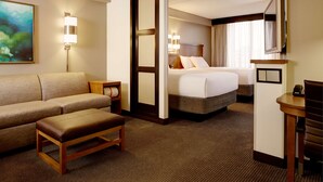 Una habitación de hotel con sofá, cama, escritorio y televisor.