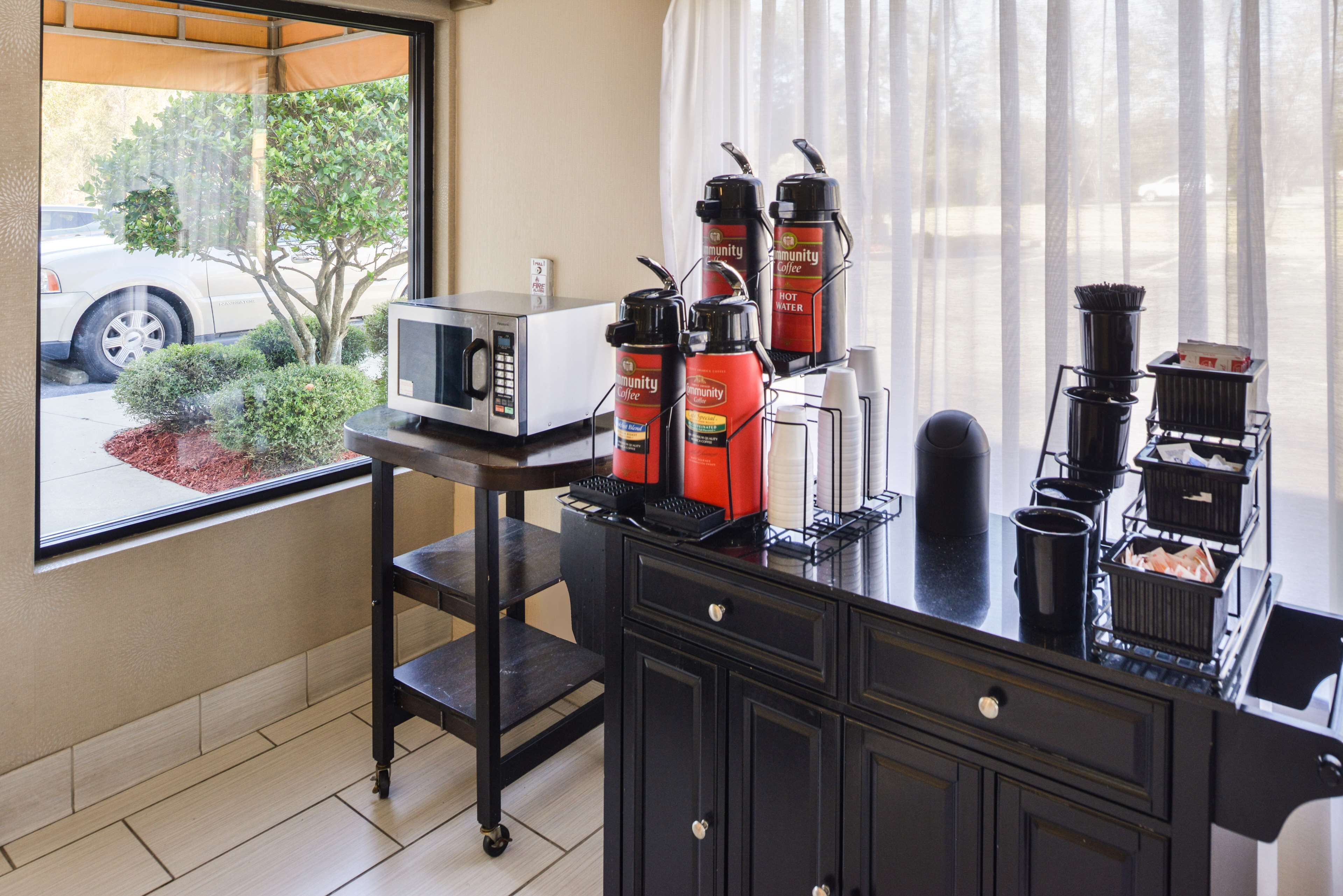 A kitchenette with a coffee station, a microwave, and a view of the street.