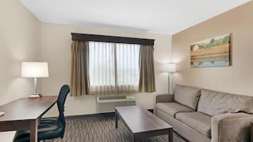 Une chambre d’hôtel équipée d’un bureau, d’une chaise, d’un canapé et d’un tableau au mur.