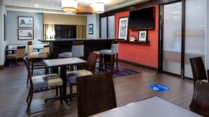 Eine Hotelhalle mit Holzboden, einer Bar und Sitzgelegenheiten.