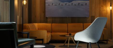 A modern lounge area with a sofa, armchairs, and a coffee table.
