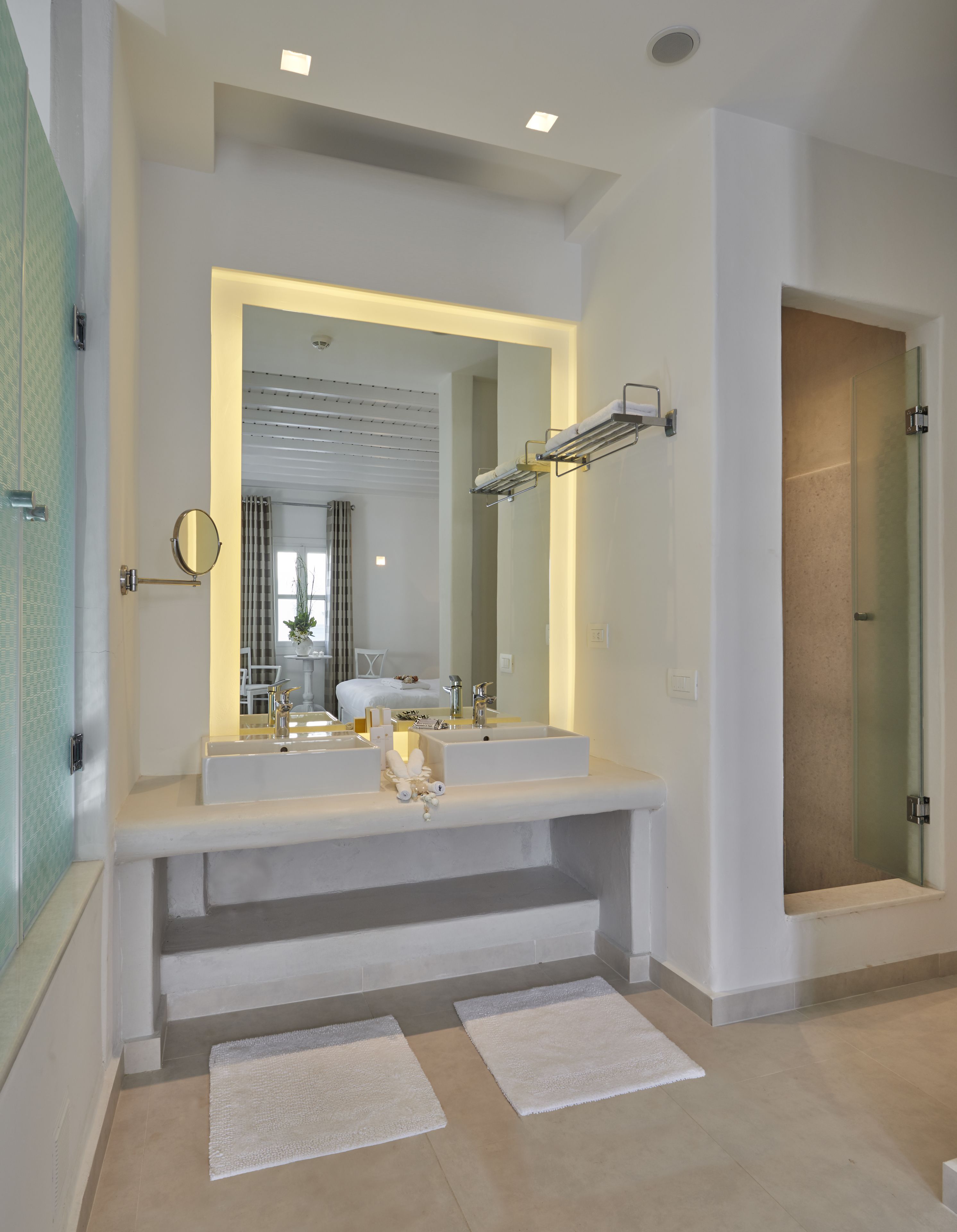 Un baño moderno con lavamanos dobles, un espejo grande y cabina de ducha de vidrio.