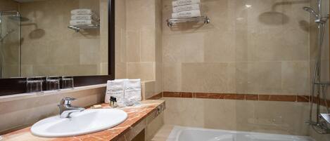A bathroom with a sink, mirror, shower, and towel rack.