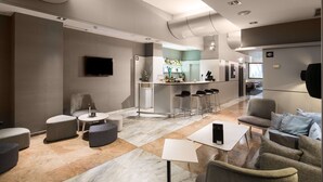 Una habitación de hotel moderna con sala de estar, cocina y bar.