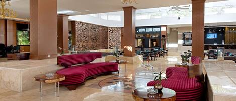 Een ruime lobby met een modern design, met een mix van zithoeken en een receptiebalie.