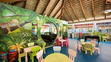 A children's play area with colorful furniture and a mural of a jungle scene.