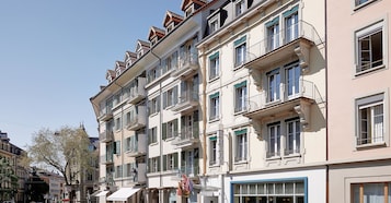 Un hotel de varios pisos con balcones, ventanas amplias y un estilo arquitectónico clásico.