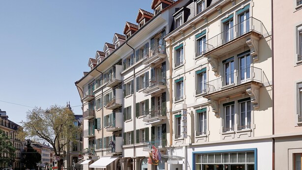 Et hotel med flere etager, altaner, store vinduer og en klassisk arkitektur.