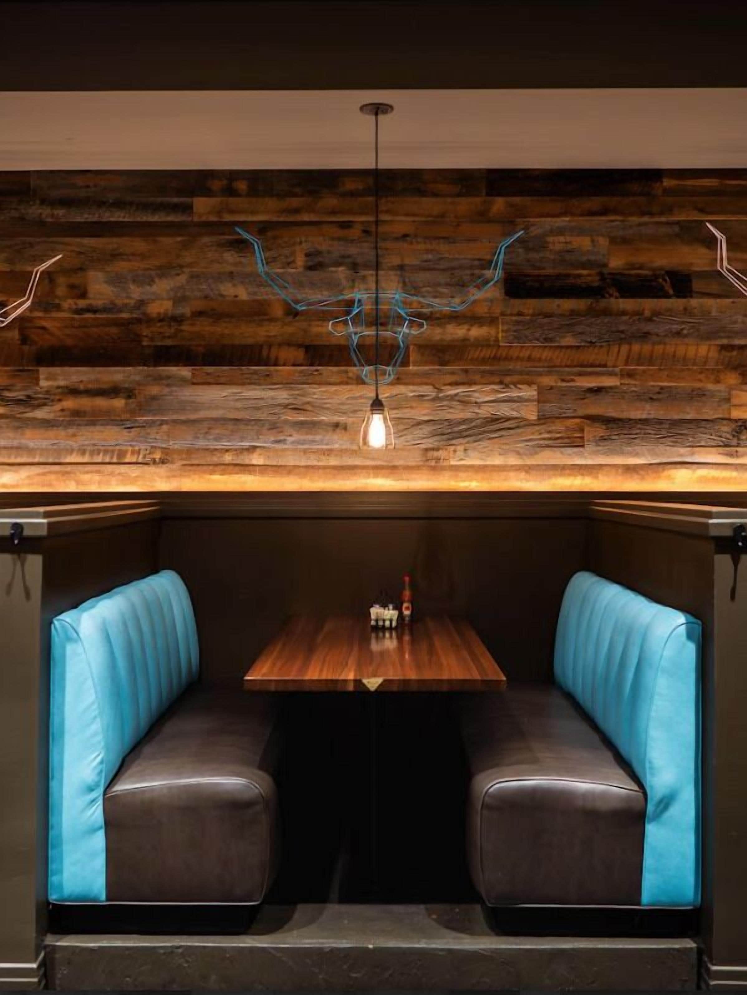 A restaurant booth with a wooden ceiling and a hanging light fixture.