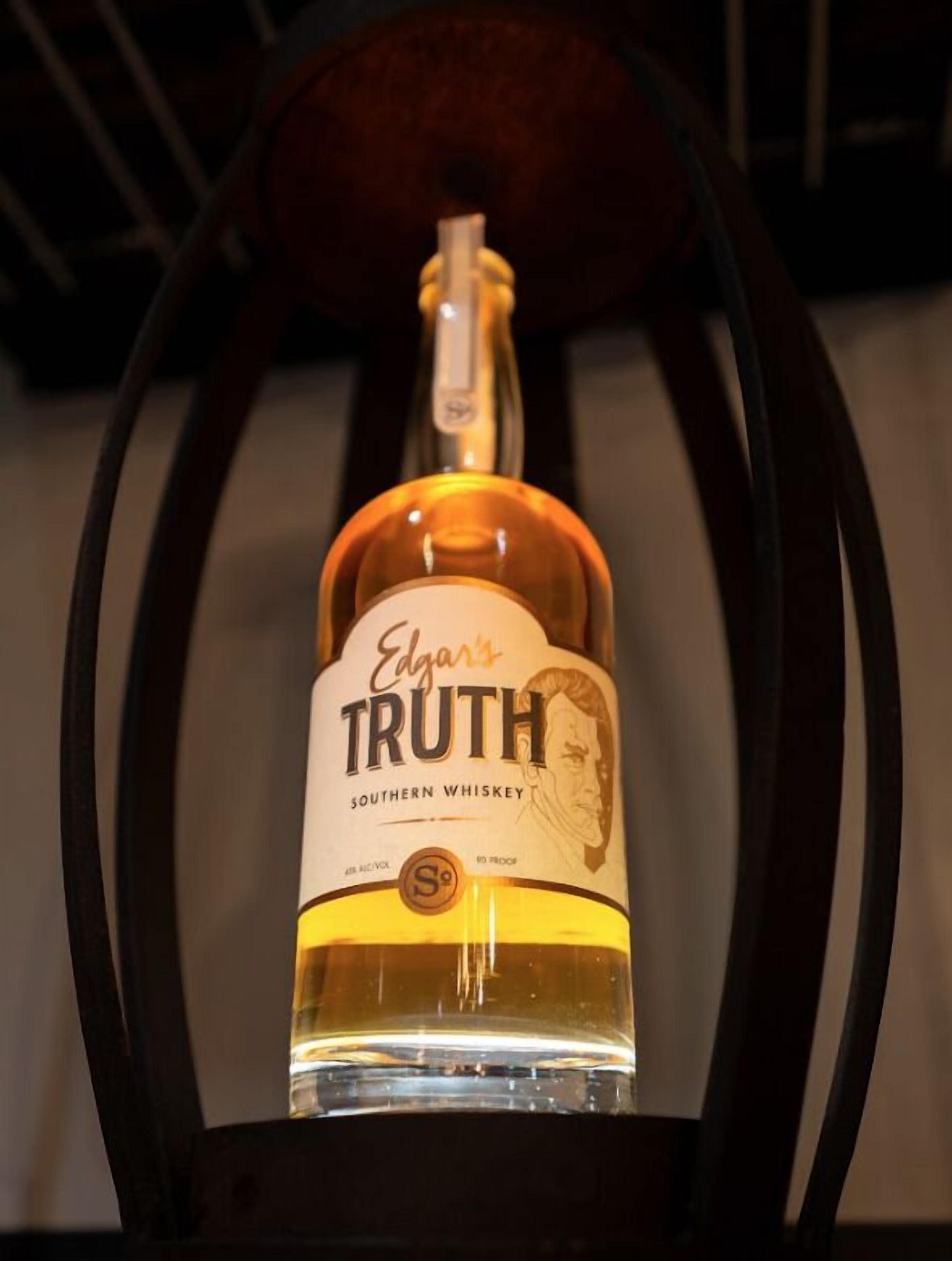 A bottle of Edgar's Truth Southern Whiskey in a wooden chair.