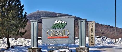 A sign for the Grand Hotel Spa in Killington, Vermont, with a mountain backdrop.