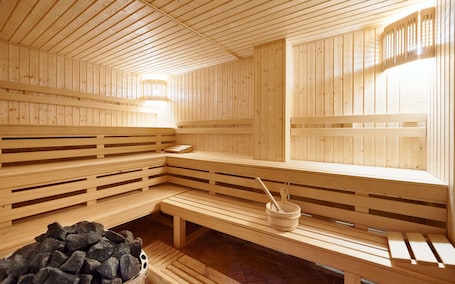 A wooden sauna with benches and a stone basin.