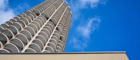 Un edificio alto con un patrón circular distintivo de balcones contra un cielo azul despejado.