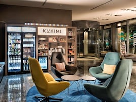 Un interior moderno con asientos, un refrigerador para bebidas y una entrada con puerta de vidrio.