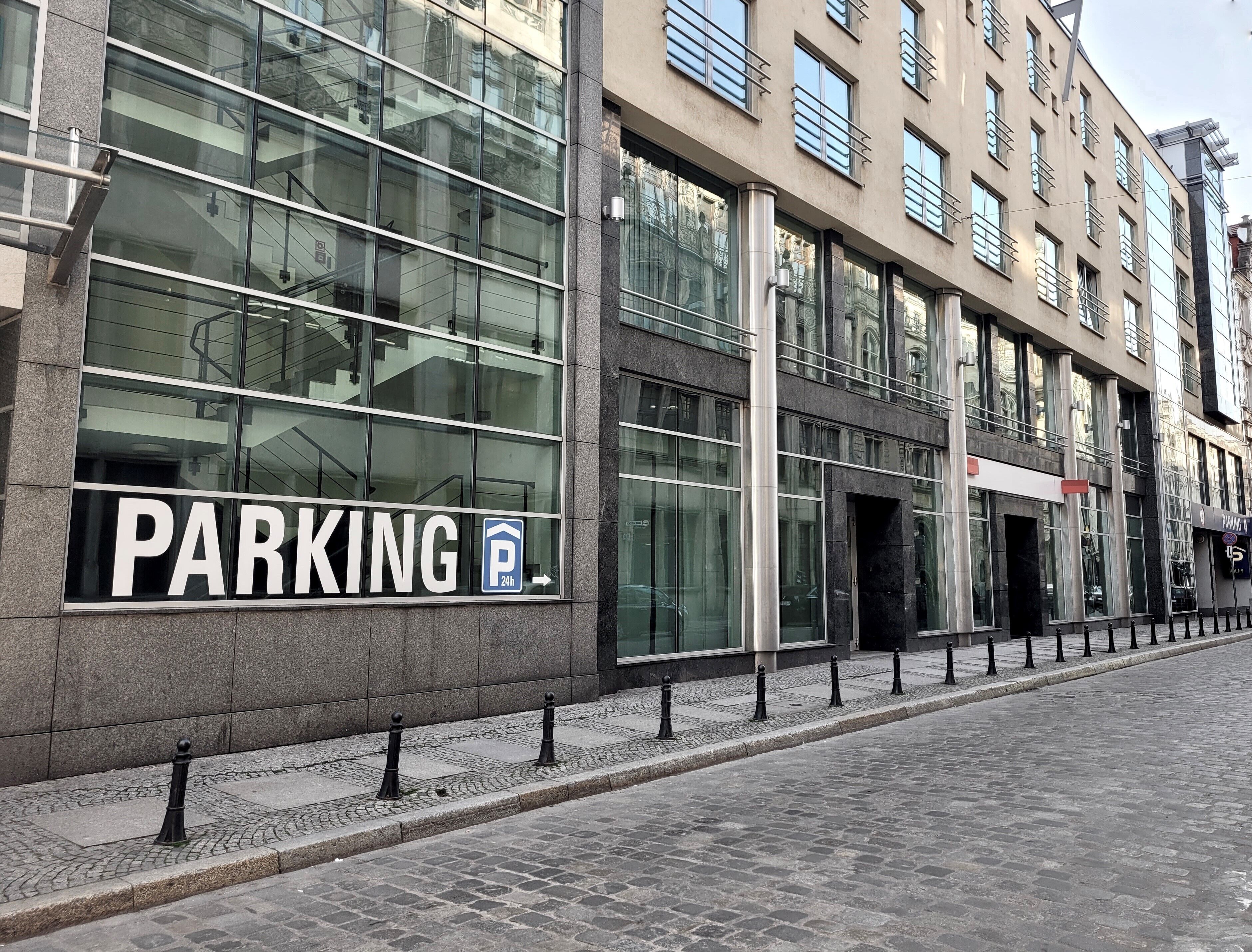 A modern building with a large parking sign indicating 24-hour access.