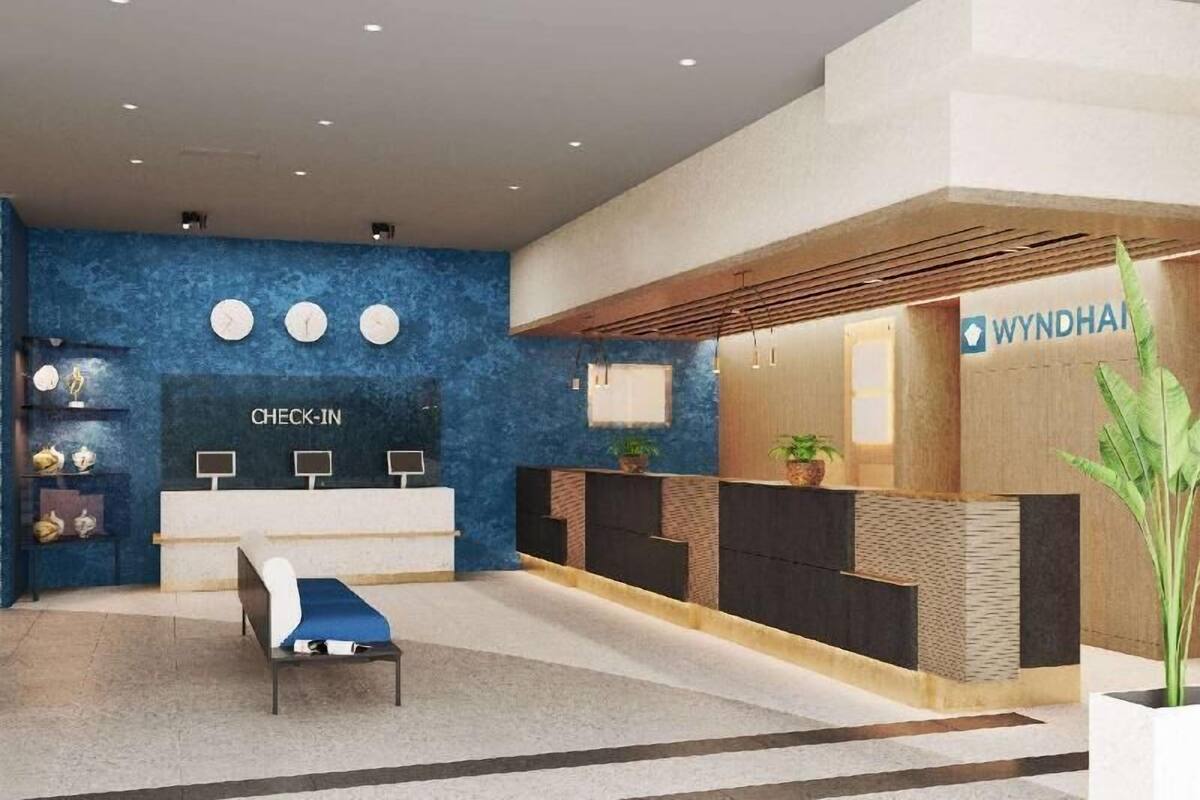 A reception area with a blue wall, a check-in counter, a waiting area with a bench, and a reception desk.