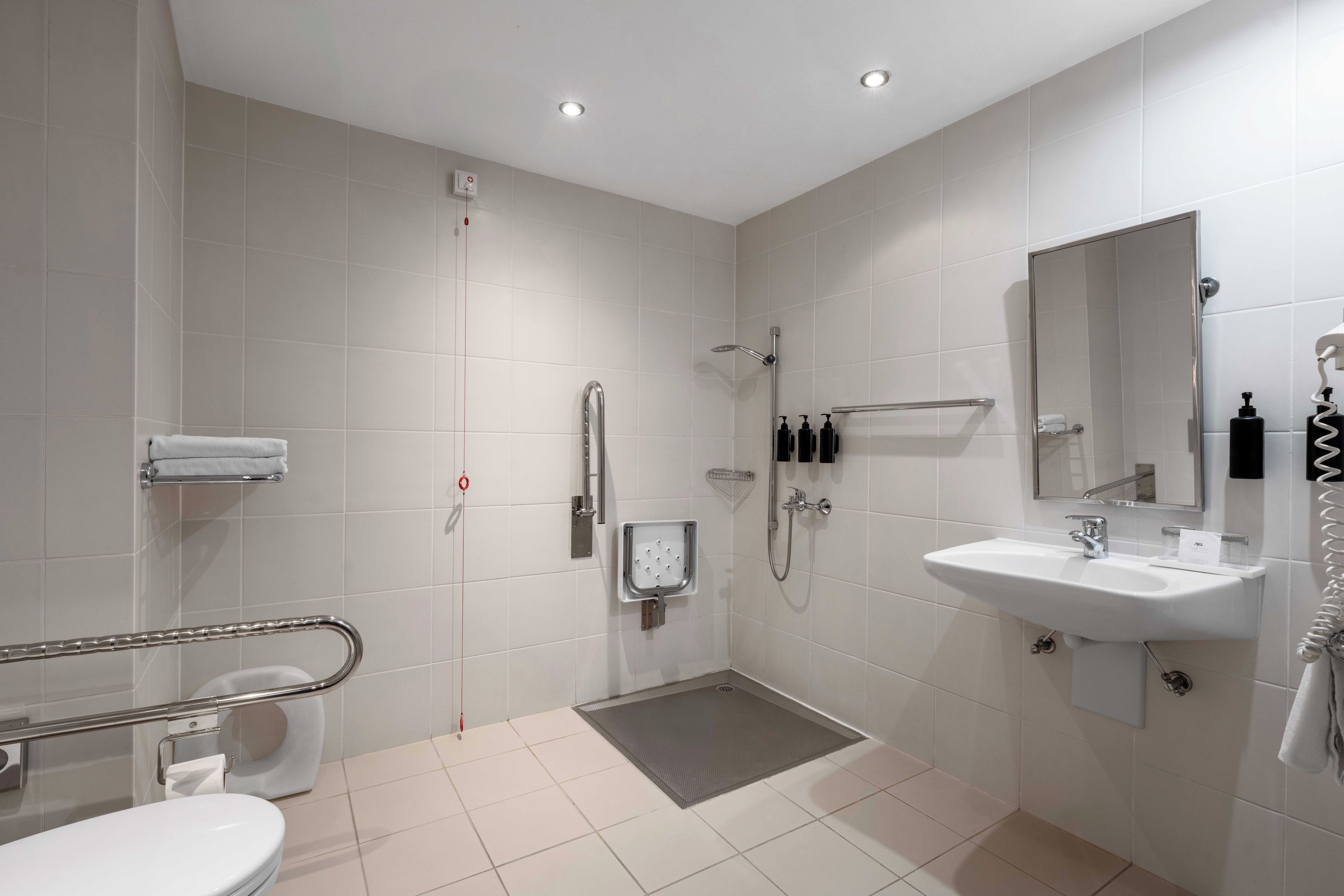 Une salle de bain moderne équipée de toilettes, d’un bidet, d’une douche et d’un lavabo.