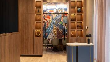 A modern room with a wooden panel wall, a colorful mural, a desk with a lamp, and a chair.